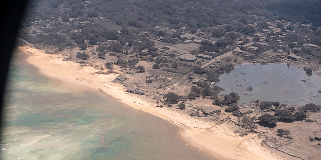 In this photo provided by the New Zealand Defense Force, volcanic ash covers rooftops and vegetation in an area of Tonga, Monday, Jan. 17, 2022. 