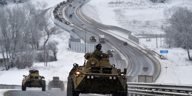A convoy of Russian armored vehicles moves along a highway in Crimea, Tuesday, Jan. 18, 2022. 
