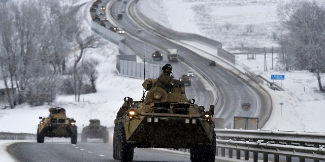 A convoy of Russian armored vehicles moves along a highway in Crimea, Tuesday, Jan. 18, 2022. 