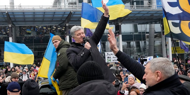 Former Ukrainian President Petro Poroshenko greets his supporters upon his arrival at Zhuliany International Airport outside Kyiv, Ukraine, Monday, Jan. 17, 2022.