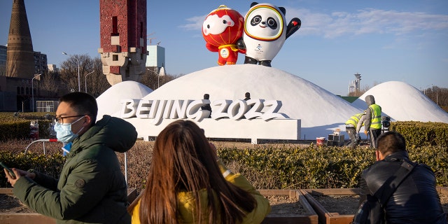 Mensen die gezichtsmaskers dragen om te helpen beschermen tegen het coronavirus, kijken naar een display van Paralympische Wintermascotte Shui Ron, links, en Winterolympische mascotte Ping Duen Duen bij de Olympische Groene Spelen in Peking, woensdag 12 januari 2022. Slechts enkele weken voor China gastheren De Olympische Winterspelen zijn in Peking en vechten tegen meerdere uitbraken van het coronavirus in een half dozijn steden, waarvan de stad die het dichtst bij de hoofdstad ligt, wordt aangedreven door de zeer overdraagbare omicron-formule.