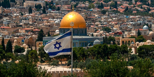 This picture taken on July 30, 2020 from the Mount of the Olives shows a view of an Israeli flag flying in Jerusalem with the Dome of the Rock seen in the background. 