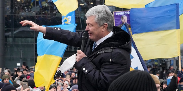 Former Ukrainian President Petro Poroshenko acknowledges supporters upon his arrival at Zhuliany International Airport outside Kyiv, Ukraine, Monday, Jan. 17, 2022. 