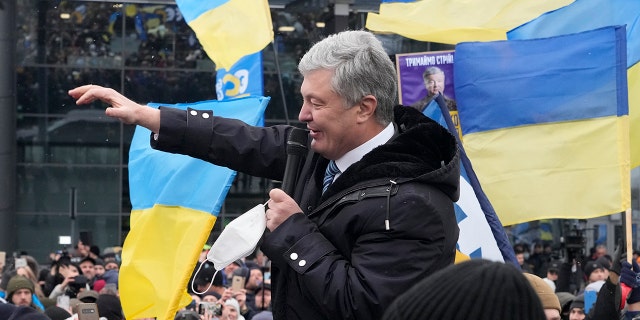 Former Ukrainian President Petro Poroshenko acknowledges supporters upon his arrival at Zhuliany International Airport outside Kyiv, Ukraine, Monday, Jan. 17, 2022.