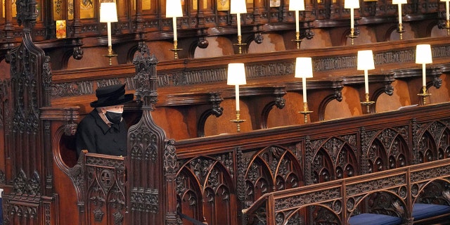 Britain's Queen Elizabeth II sits alone in St. George's Chapel during the funeral of Prince Philip, the man who had been by her side for 73 years, at Windsor Castle, Windsor, England, Saturday, April 17, 2021.
