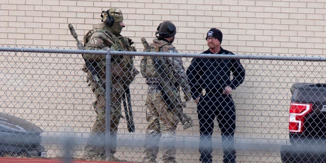 Law enforcement officials gather at a local school near the Congregation Beth Israel synagogue on Saturday, Jan.. 15, 2022 in Colleyville, Texas.