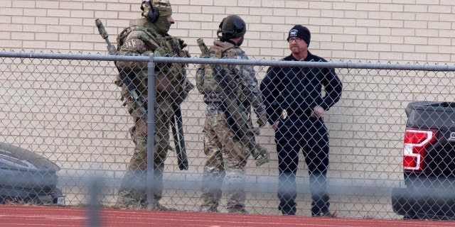 Law enforcement officials gather at a local school near the Congregation Beth Israel synagogue on Saturday, Jan. 15, 2022, in Colleyville, Texas.