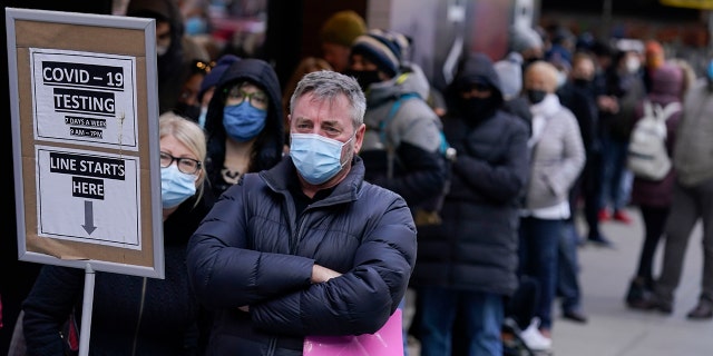 People wait in line at a COVID-19 testing site in New York's Times Square on Dec. 13, 2021.