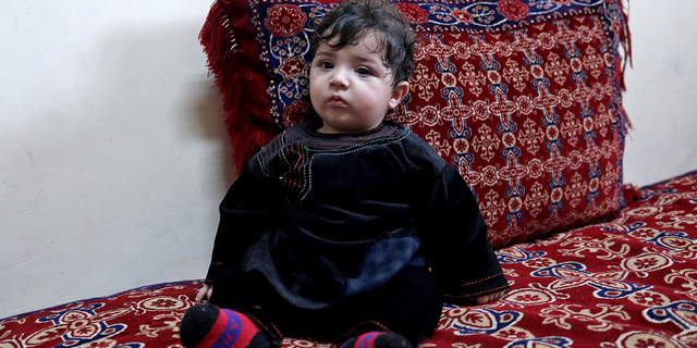 Baby Sohail Ahmadi sits inside the house of Hamid Safi, a taxi driver who had found Sohail in the airport, in Kabul, Afghanistan, January 7, 2022. Picture taken January 7, 2022. REUTERS/Ali Khara