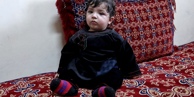Baby Sohail Ahmadi sits inside the house of Hamid Safi, a taxi driver who had found Sohail in the airport, in Kabul, Afghanistan, January 7, 2022. Picture taken January 7, 2022. REUTERS/Ali Khara