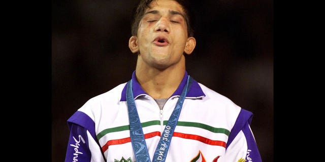 Alireza Dabir of Iran, receives gold medal for 58 kg Freestyle Wrestling at Sydney 2000 Summer Olympic Games, photo on black