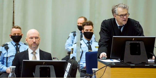 Convicted mass murderer Anders Behring Breivik, left, and defense lawyer Oystein Storrvik participate in the makeshift courtroom in Skien prison on the third day of the trial, where he is requesting release on parole, in Skien, Norway, Jan. 20, 2022. 