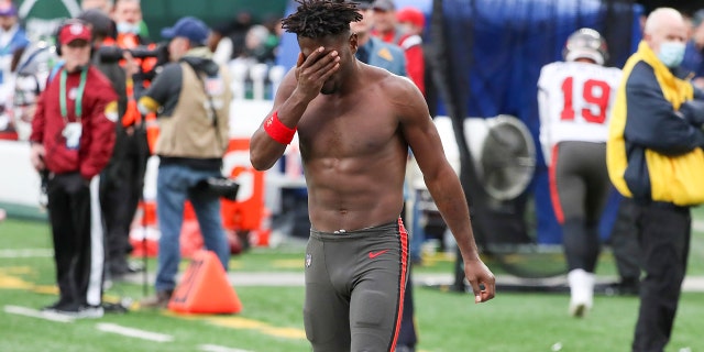 El receptor abierto de los Tampa Bay Buccaneers, Antonio Brown, se limpia la cara al salir del campo después de arrojar su equipo a las gradas mientras su equipo estaba a la ofensiva en el tercer cuarto de un partido contra los New York Jets el 2 de enero de 2022, en East Rutherford, EE. New Jersey 