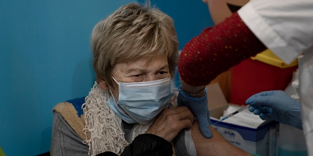 A woman receives her fourth dose of the coronavirus vaccine at Clalit Health Services in Jerusalem, Monday, Jan. 3, 2022. I