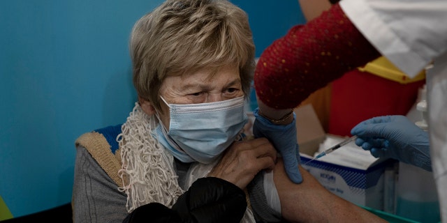 A woman receives her fourth dose of the coronavirus vaccine at Clalit Health Services in Jerusalem, Monday, Jan. 3, 2022. I