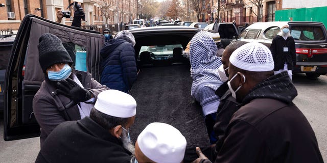 People move a casket to a hearse after the funeral service for victims from the apartment building which suffered the city's deadliest fire in three decades, at the Islamic Cultural Center for the Bronx on Sunday, Jan. 16, 2022, in New York. 