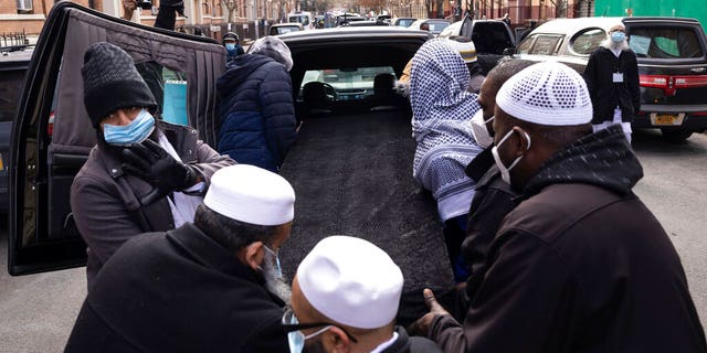 People move a casket to a hearse after the funeral service for victims from the apartment building which suffered the city's deadliest fire in three decades, at the Islamic Cultural Center for the Bronx on Sunday, Jan. 16, 2022, in New York. 