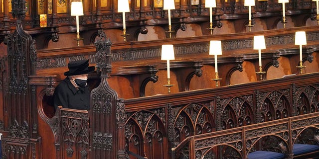 Britain's Queen Elizabeth II sits alone in St. George's Chapel during the funeral of Prince Philip, the man who had been by her side for 73 years, at Windsor Castle, Windsor, England, Saturday, April 17, 2021.  (Jonathan Brady/Pool via AP, File)