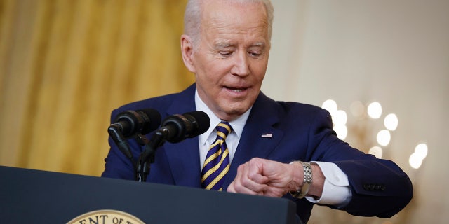 President Biden checks his watch while answering questions during a news conference in the East Room of the White House on January 19, 2022 in Washington. (Photo by Chip Somodevilla/Getty Images)