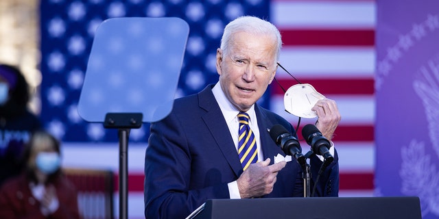 U.S. President Joe Biden removes his face mask before speaking at the Atlanta University Center Consortium in Atlanta, Georgia, U.S., Tuesday, January 11, 2022.