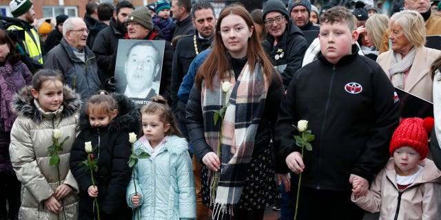 People take part in a march to commemorate the 50th anniversary of the Bloody Sunday shootings with photographs of some of the victims in Londonderry, Sunday, Jan. 30, 2022. In 1972, British soldiers shot 28 unarmed civilians at a civil rights march, killing 13 on what is known as Bloody Sunday or the Bogside Massacre. Sunday marks the 50th anniversary of the shootings in the Bogside area of Londonderry.