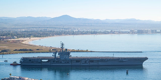 This aerial photo released by the U.S. Navy shows the aircraft carrier USS Abraham Lincoln (CVN-72) as it deploys from San Diego on Monday, Jan. 3, 2022. 