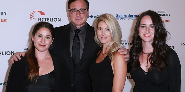 Saget poses with Rizzo and two of his daughters.