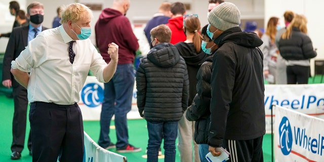 Britain's Prime Minister Boris Johnson, left, visits a vaccination hub in the Stoke Mandeville Stadium in Aylesbury, England, Monday Jan. 3, 2022, as the booster vaccination program continues.