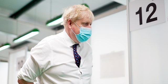 Britain's Prime Minister Boris Johnson visits a vaccination hub in the at Stoke Mandeville Stadium in Aylesbury, England, Monday Jan. 3, 2022, as the booster vaccination programme continues. 