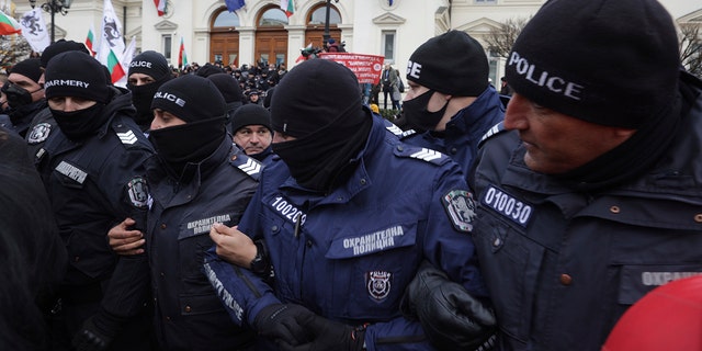 Ofițerii de poliție încearcă să alunge protestatarii de la clădirea Parlamentului bulgar din Sofia miercuri, 12 ianuarie 2022. Protestatarii care se opun restricțiilor COVID-19 din Bulgaria s-au ciocnit cu poliția în timp ce încercau să atace Parlamentul din Sofia.  O prezență puternică a poliției a împiedicat protestatarii să intre în clădire, iar unii au fost arestați. 
