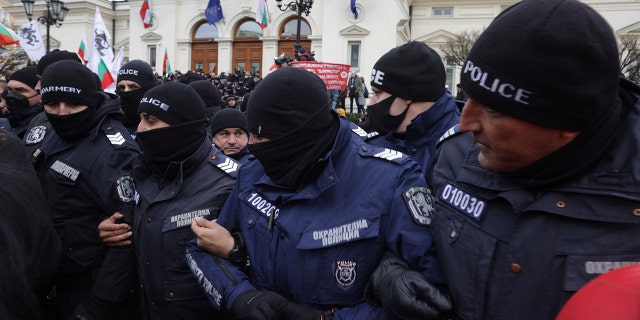 Police officers attempt to drive protesters away from the Bulgarian Parliament building in Sofia on Wednesday, January 12, 2022. Protesters opposing COVID-19 restrictions in Bulgaria clashed with police as they attempted to storm the Parliament in Sofia. A heavy police presence prevented protesters from entering the building and some were arrested.