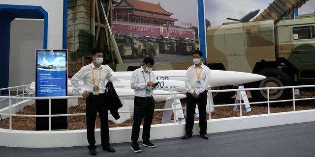 Workers wearing masks stand near missiles produced by China Aerospace Science and Industry Corp.displayed during the 13th China International Aviation and Aerospace Exhibition, also known as Airshow China 2021 on Tuesday, Sept. 28, 2021 in Zhuhai in southern China's Guangdong province.