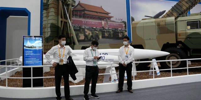 Workers wearing masks stand near missiles produced by China Aerospace Science and Industry Corp.displayed during the 13th China International Aviation and Aerospace Exhibition, also known as Airshow China 2021 on Tuesday, Sept. 28, 2021 in Zhuhai in southern China's Guangdong province.