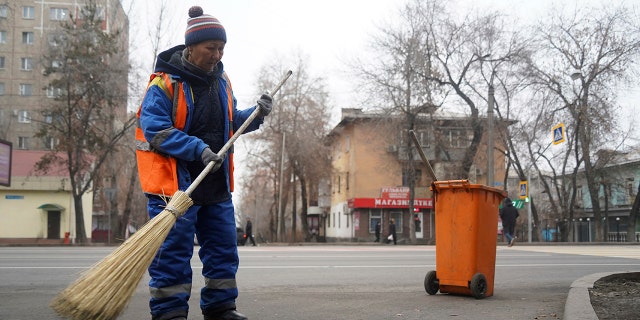 A municipal worker sweeps the street in Almaty, Kazakhstan on Monday, January 10, 2022.