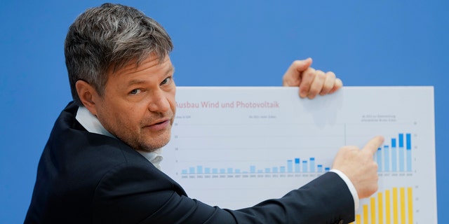 Le ministre allemand de l'Économie et du Climat, Robert Habeck, montre un carton avec un graphique pour développer l'énergie éolienne et photovoltaïque lors d'une conférence de presse sur la politique climatique du gouvernement allemand à Berlin, en Allemagne, le mardi 11 janvier 2022.