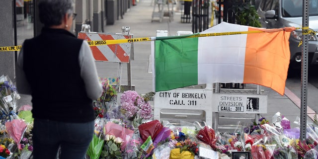 A woman views a memorial for those who lost their lives after a balcony gave way in Berkeley, California, in 2015.