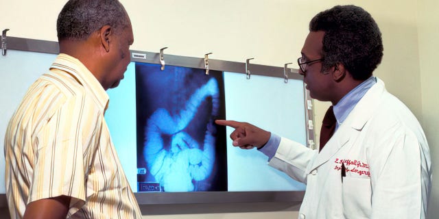 A doctor goes over a patient's x-ray, screening for colon cancer.