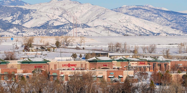 Snow covers a smoke-damaged shopping center after wildfires ravaged the area Sunday, Jan. 2, 2022, in Superior, Colorado.
