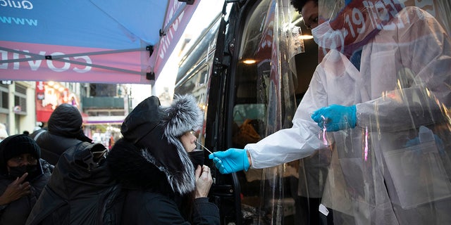NEW YORK, NEW YORK - JANUARY 04: A woman gets tested at a mobile COVID-19 testing van on 14th street in Manhattan on January 4, 2022 in die stad New York. (Photo by Liao Pan/China News Service via Getty Images)