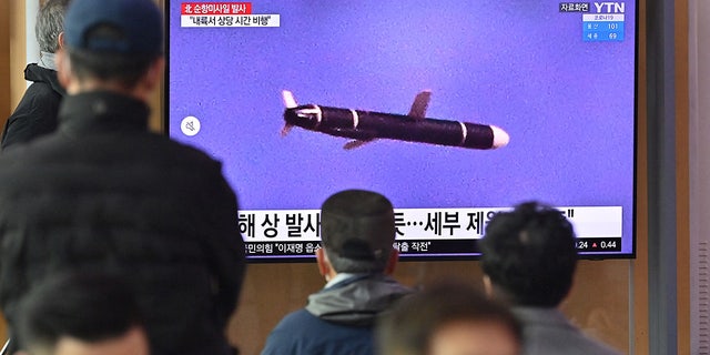 People watch a television screen showing a news broadcast with file footage of a North Korean missile test, at a railway station in Seoul on January 25, 2022, after North Korea fired two suspected cruise missiles according to the South's military. (Photo by JUNG YEON-JE/AFP via Getty Images)