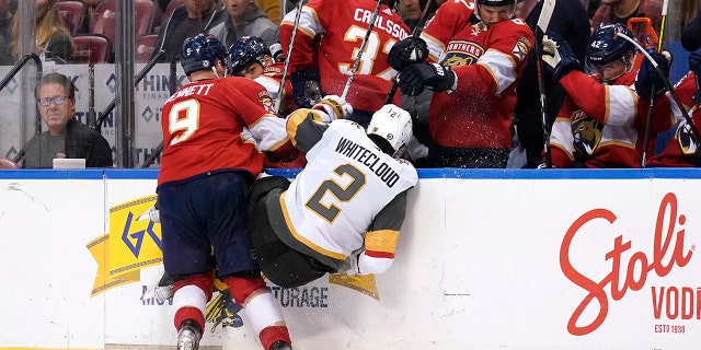Florida Panthers center Sam Bennett (9) and Vegas Golden Knights defenseman Zach Whitecloud (2) go into the boards during the second period of an NHL hockey game, 星期四, 一月. 27, 2022, in Sunrise, 弗拉.