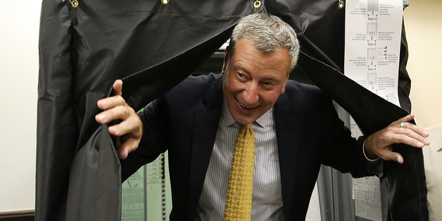 De Blasio emerges from a voting booth after voting in the New York City mayoral primary Sept. 10, 2013, in Brooklyn.
