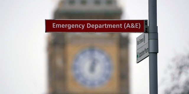 Un panneau du service des urgences de l'hôpital St Thomas est entouré par la tour Elizabeth du Parlement, connue sous le nom de Big Ben, à Londres, le jeudi 6 janvier 2022. 