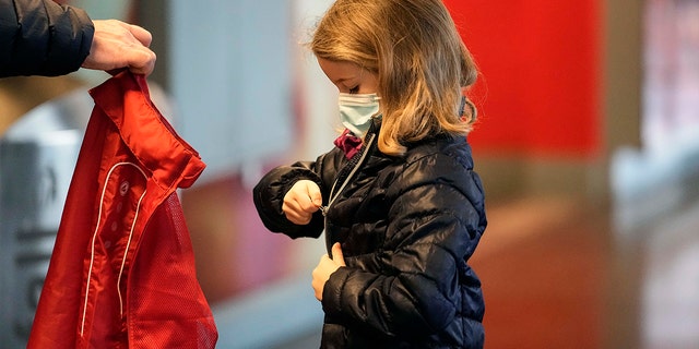 Lotte, six ans, met sa veste après avoir reçu son deuxième vaccin contre le coronavirus contre la maladie COVID-19 au Laxness-Arena de Cologne, en Allemagne, le vendredi 7 janvier 2022, où tous les enfants participants ont été récompensés pour leur vaccination. 