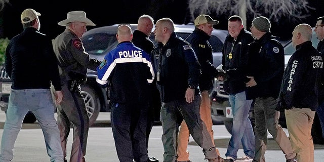 Law enforcement officials talk to each other after a news conference where they announced that all hostages at Congregation Beth Israel synagogue were safe and the hostage taker was dead on Saturday, Jan. 15, 2022, in Colleyville, Texas.