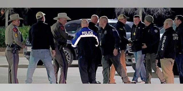 Law enforcement officials talk to each other after a news conference where they announced that all hostages at Congregation Beth Israel synagogue were safe and the hostage taker was dead on Saturday, Jan. 15, 2022, in Colleyville, Texas. (AP Photo/Tony Gutierrez)