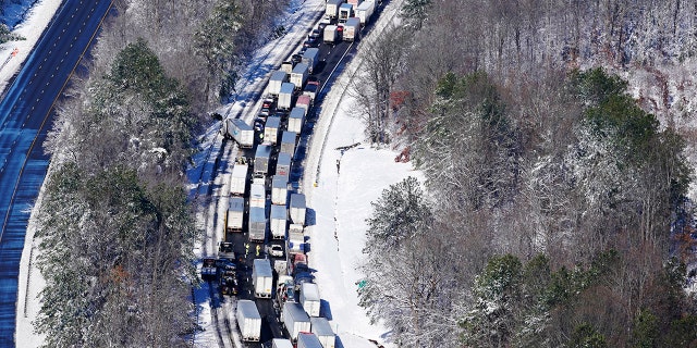 Drivers wait for the traffic to be cleared as cars and trucks are stranded on sections of Interstate 95, Jan. 4, 2022, in Carmel Church, Virginia. Close to 48 miles of the Interstate was closed due to ice and snow. 