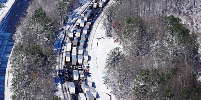 Drivers wait for the traffic to be cleared as cars and trucks are stranded on sections of Interstate 95, Jan. 4, 2022, in Carmel Church, Virginia. Close to 48 miles of the Interstate was closed due to ice and snow. 