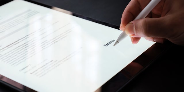 A businessman signing an electronic contract.