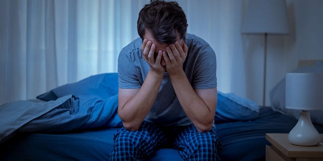 رجل مكتئب في الليل يشعر بالوحدة وعدم النفع.  فاقم جائحة COVID-19 بعض حالات الصحة العقلية ، مع زيادة الاكتئاب والقلق بأكثر من 25٪ خلال عامه الأول وحده. 